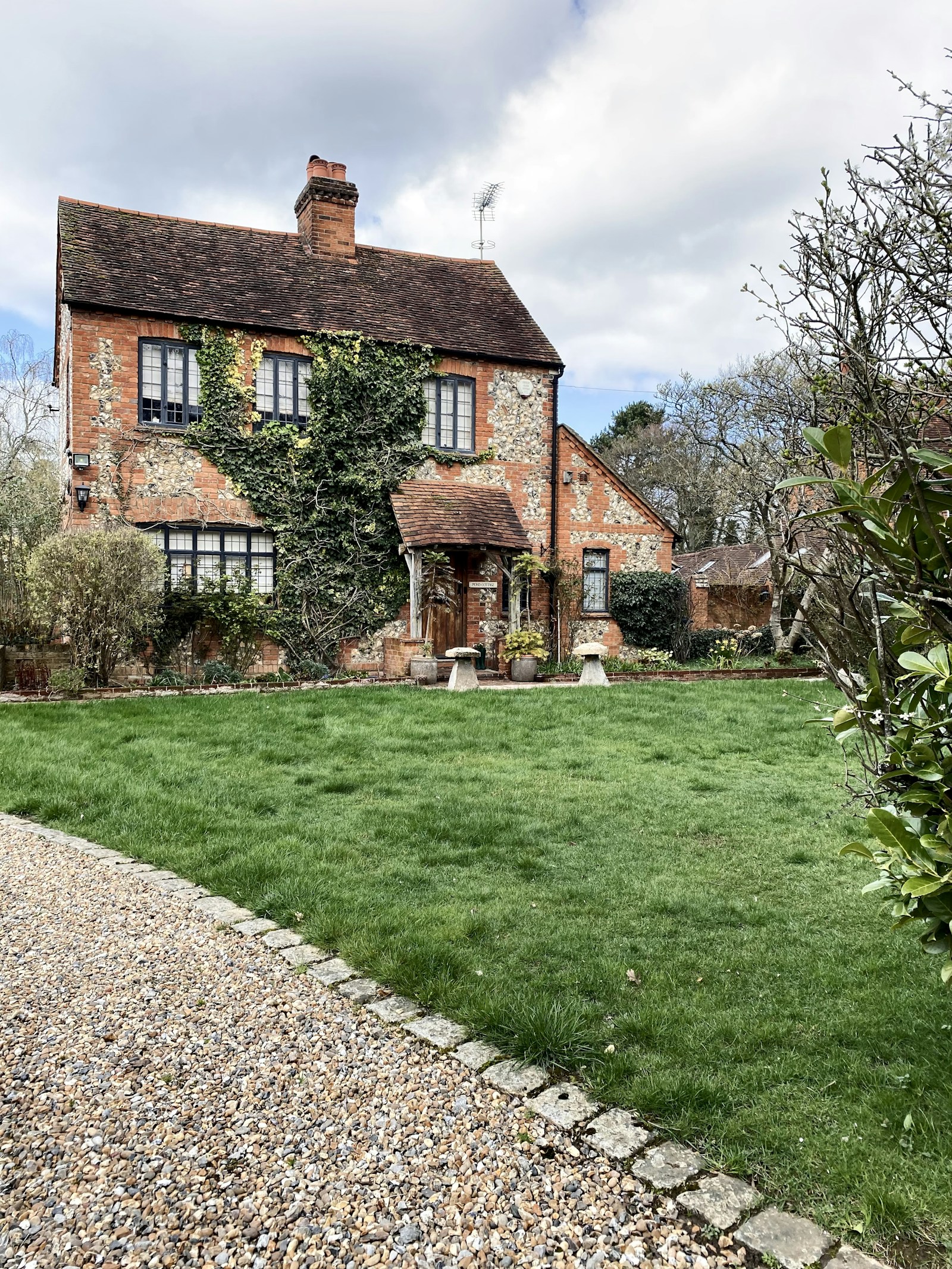 An English brick and flint cottage with a garden and mature trees